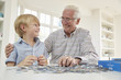 © Monkey Business - Senior man and grandson doing a jigsaw puzzle at home