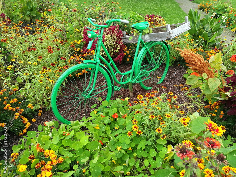 Grünes Fahrrad als Dekoration in einem grünen Park mit Blumenbeet im Sommer im Landschaftspark in Oelde bei Warendorf im Münsterland in Westfalen Stock Photo