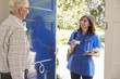 © Monkey Business - Female nurse showing ID to senior man at his front door