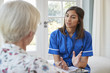 © Monkey Business - Senior woman talking to young care nurse on home visit