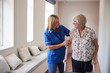 © Monkey Business - Nurse helping senior woman use a walking frame