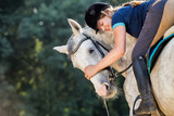 Fototapeta Konie - Woman riding a horse on paddock, horsewoman sport wear