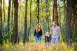 © Tortuga - happy family walking in beautiful evening park, holding hands and smiling