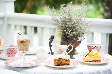 luxury vintage coffee cup and tea, fruit cake,vintage milk jug, vintage flora on aged white table at balcony for breakfast