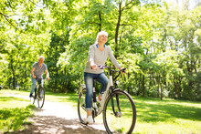 Senior Couple Riding Bikes In Park

