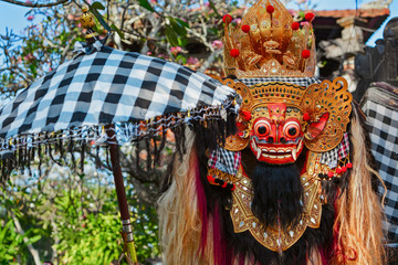 Wall Mural - Rangda Mask under red umbrella in temple - traditional spirit of Bali at ceremony Melasti before Balinese New Year and silence day Nyepi Holidays, festivals, rituals, art, culture of Indonesian people