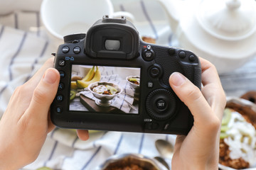 Wall Mural - Young woman taking photo of delicious dessert in bowl with professional camera