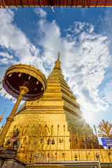 Wat Phra That Cho Hae Buddhism Temple with golden pagoda on blue sky background. Places worship of buddhists and attractions famous religion at Phrae Province, Thailand