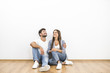 © realstock1 - The happy couple sit on the background of the white wall