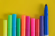 rows of colorful marker on yellow paper background