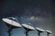 Satellite dishes on building for telecommunication with milky way sky background