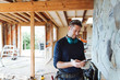 © Rob and Julia Campbell/Stocksy - Carpenter contractor texting on cell phone inside home renovation