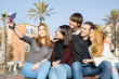 © BONNINSTUDIO/Stocksy - Group of teen friends taking a selfie with their phone outside.