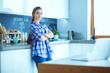 © lenets_tan - Portrait of young woman standing with arms crossed against kitchen background.