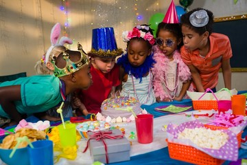 Wall Mural - Children blowing candles on cake