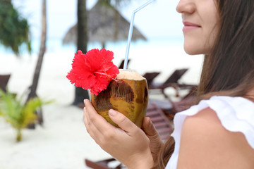 Wall Mural - Young woman with fresh coconut cocktail at resort, closeup