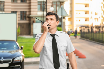 Wall Mural - Male security guard with portable radio, outdoors