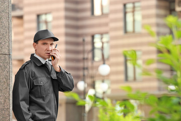 Wall Mural - Male security guard with portable radio, outdoors