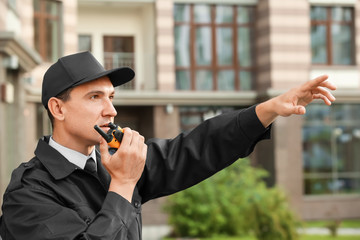 Wall Mural - Male security guard with portable radio, outdoors