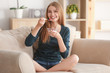 © Africa Studio - Young woman eating yogurt on sofa at home