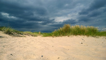 The Approaching Storm Cloud On The Beach With Dunes And Pure White Sand