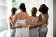 Rear view of bride and bridesmaids standing together near window