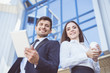 © realstock1 - The man and woman stand with a tablet on the background of the building