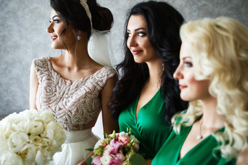 Wall Mural - Profiles of bride and bridesmaids in green dresses sitting in the room