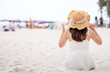 © Nattakorn - Asian woman on white dress standing over the blue sea and sky, feeling relaxing and happy on vacation in summer holiday