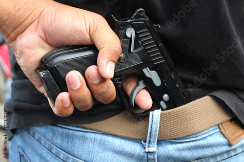 Plakat gangster ukrywający broń za plecami