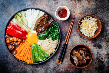 Bibimbap, traditional Korean dish, rice with vegetables and beef. Top view, overhead, flat lay