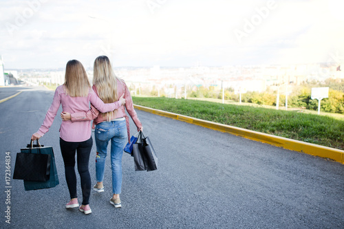 Young Girls Arm In Arm Walking Down The Street With Shopping Stock Photo Adobe Stock
