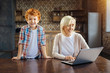 © zinkevych - Excited kid joining his grandmother working on laptop