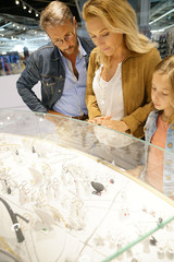 Wall Mural - Family in shopping mall looking at jewelry department