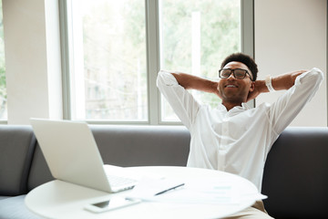 Sticker - Cheerful young african man sitting coworking by laptop