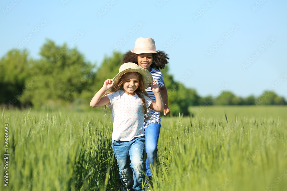 Happy little girls in green field