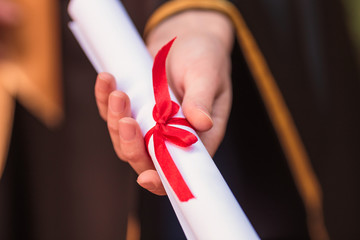 Close-up a diploma in hand of graduate