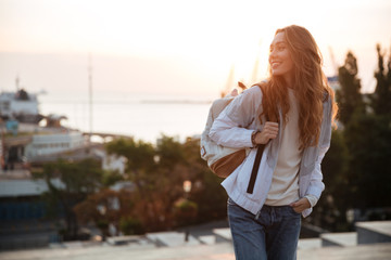 Sticker - Happy brunette woman in autumn clothes and with backpack