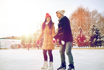 Canvas Print - happy couple ice skating on rink outdoors