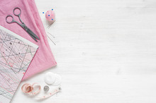 Pink Natural Fabric And Sewing Tools On  The White Wooden Table