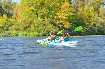 Wall Mural - Family kayaking, mother and child paddling in kayak on river canoe tour, active summer weekend and vacation, sport and fitness concept
