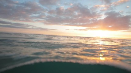 Wall Mural - sunset at the ocean and surfing wave rushing to the shore