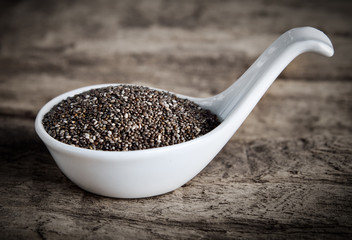 Wall Mural - Healthy Chia seeds in spoon on wooden background.