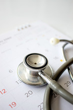 Annual Checkup Concept. Stethoscope On The Calendar With Soft-focus And Over Light In The Background