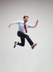 Wall Mural - Businessman running on gray background