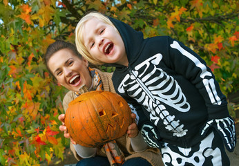 Wall Mural - mother and child showing carved Halloween pumpkin