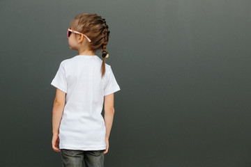 Girl kid wearing white blank  t-shirt with space for your logo or design in casual urban style