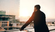 © Jacob Lund - Businessman standing in airport lounge balcony and looking outsi