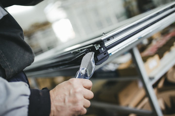 Wall Mural - Manual worker assembling PVC doors and windows. Manufacturing jobs. Selective focus. Factory for aluminum and PVC windows and doors production.