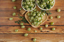 High Angle View Of Gooseberries In Containers On Wooden Table